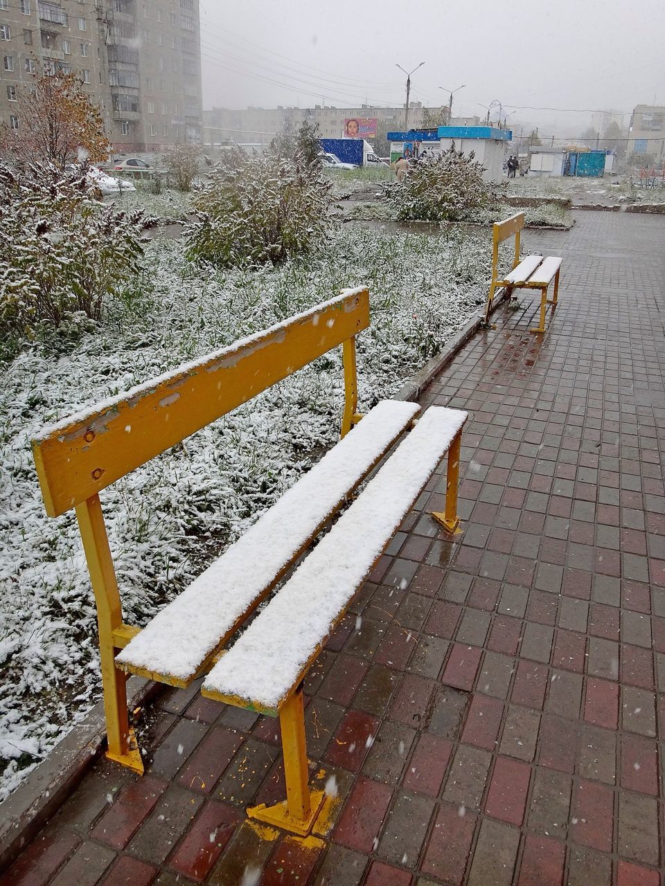 street, high angle view, built structure, building exterior, sidewalk, bench, architecture, day, outdoors, road, empty, season, transportation, city, no people, railing, asphalt, yellow, the way forward, sunlight