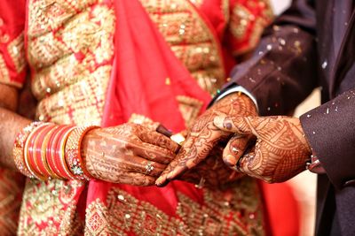 Midsection of couple holding hands