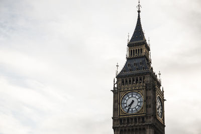 Low angle view of clock tower against cloudy sky