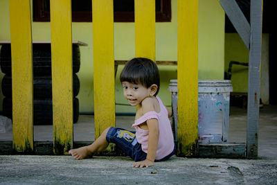 Full length portrait of boy sitting outdoors