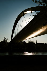 Bridge over river against sky during sunset