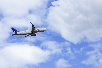 Low angle view of airplane flying against sky