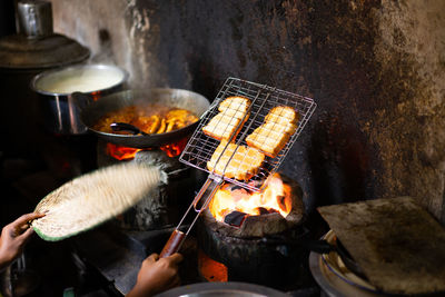 Hand holding toast on barbecue grill