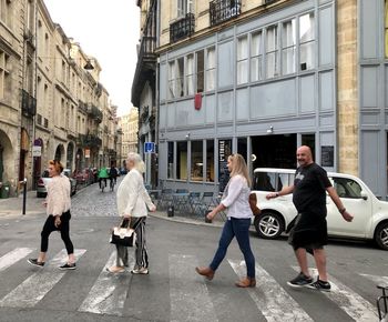 People walking on road along buildings
