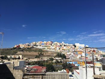 Buildings in city against blue sky