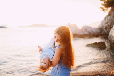 Cheerful mother and daughter enjoying at beach