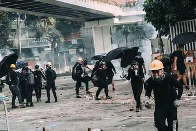 People walking on wet street during rainy season