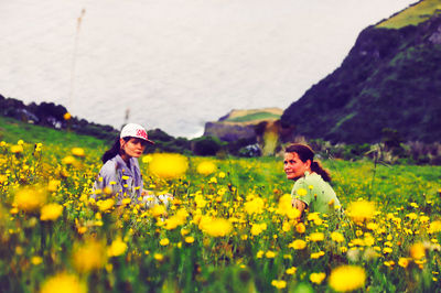 Full length of woman with yellow flowers on field