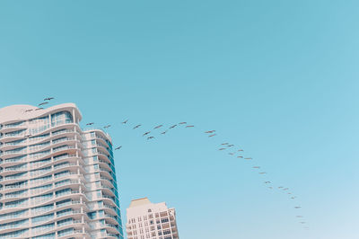 Low angle view of buildings against clear blue sky