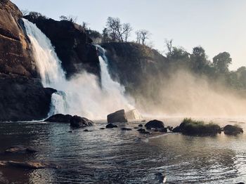 Scenic view of waterfall against sky