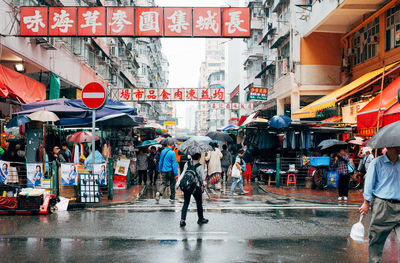 People walking on wet street in city