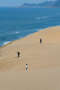 People walking on beach against sky