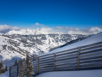 Scenic view of snow covered mountains against blue sky