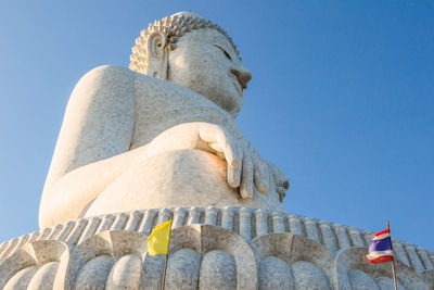 Low angle view of buddha statue against clear sky