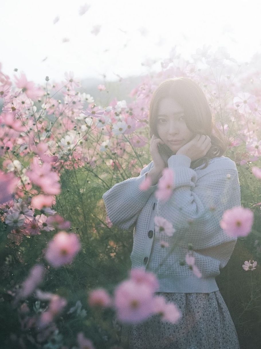 WOMAN STANDING ON PINK FLOWERING PLANT