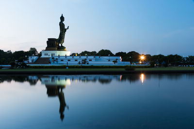 Statue by swimming pool against sky at sunset