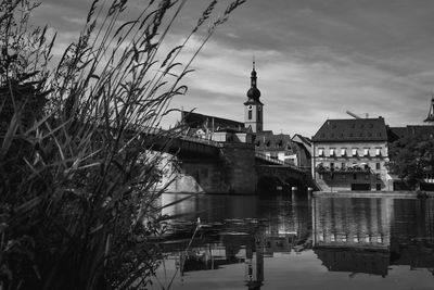 Arch bridge over river against buildings in city