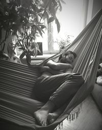 Young man sleeping in hammock at home