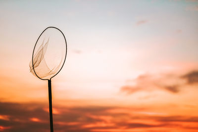 Low angle view of basketball hoop against sky during sunset