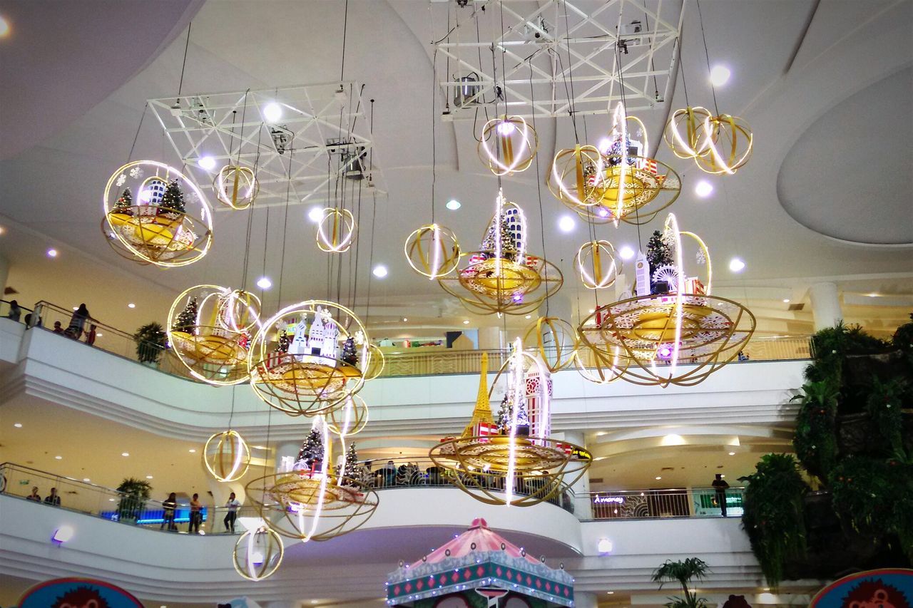 indoors, illuminated, lighting equipment, hanging, ceiling, variation, table, large group of objects, arrangement, decoration, multi colored, glass - material, chair, abundance, restaurant, in a row, no people, luxury, absence, high angle view