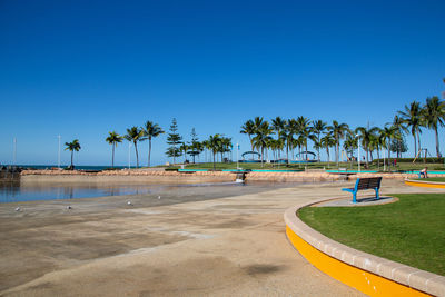 Scenic view of palm trees against clear blue sky