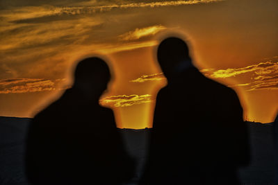 Close-up of silhouette person standing against orange sky