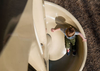 High angle view of boy playing on slide at playground