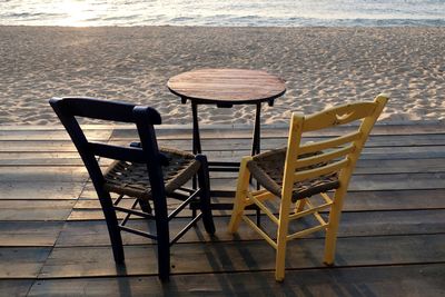 Empty chairs and table at beach