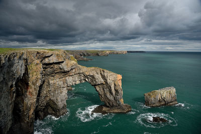 Rock formations by sea against sky