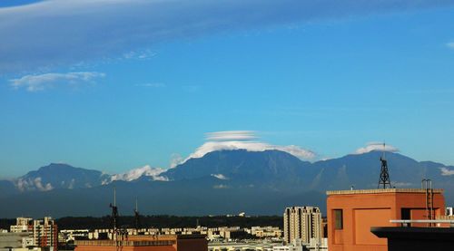 Houses and mountains against blue sky