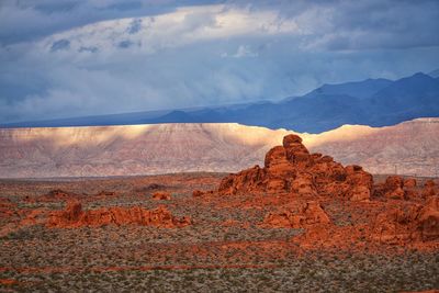 Rock formations on landscape against cloudy sky