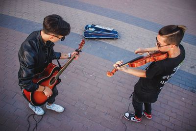 High angle view of boys playing guitar on street