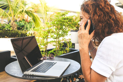 Man using mobile phone while sitting on table