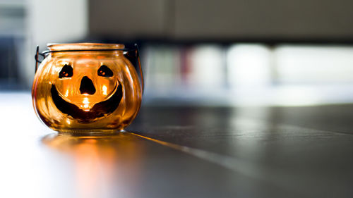 Close-up of illuminated candle on table