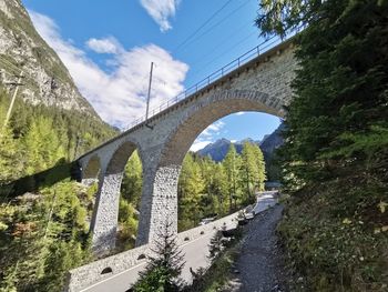 Arch bridge over road against sky