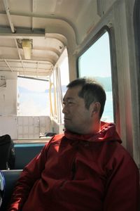 Portrait of man sitting in small ferry