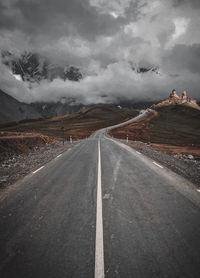Empty road along countryside landscape