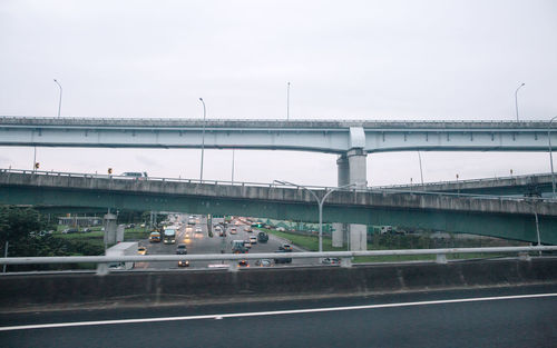 Bridge over river against sky in city