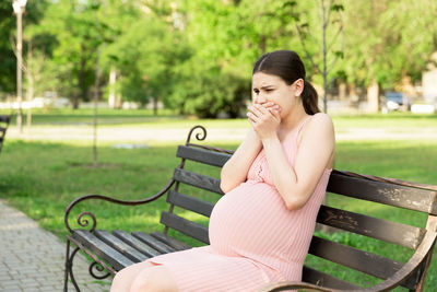 Woman sitting on bench in park