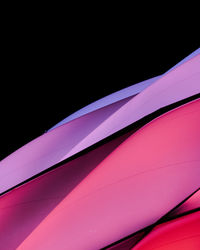 Close-up of pink umbrella against black background