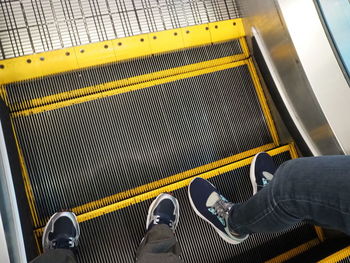Low section of man standing on escalator
