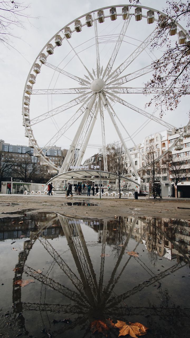 REFLECTION OF FERRIS WHEEL IN CITY