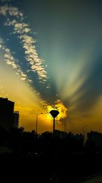 Silhouette city against sky during sunset