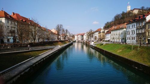 Canal amidst buildings in city against sky