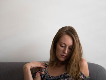 Portrait of a beautiful young woman against wall