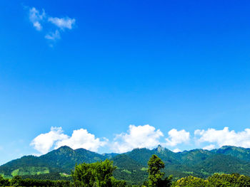 Scenic view of mountains against blue sky