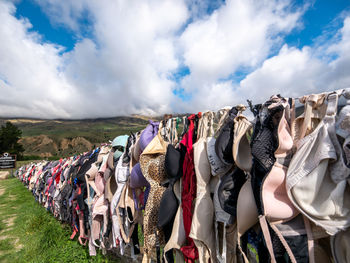 Clothes drying on clothesline at market against sky