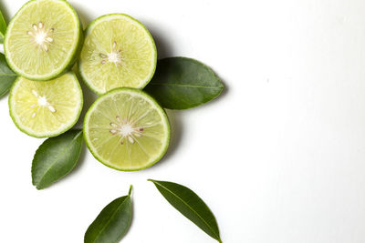 High angle view of fruits and leaves on white background