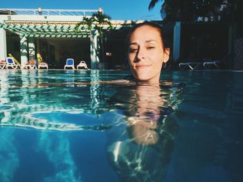 Portrait of smiling young woman swimming pool