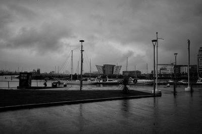 Boats moored at harbor against sky